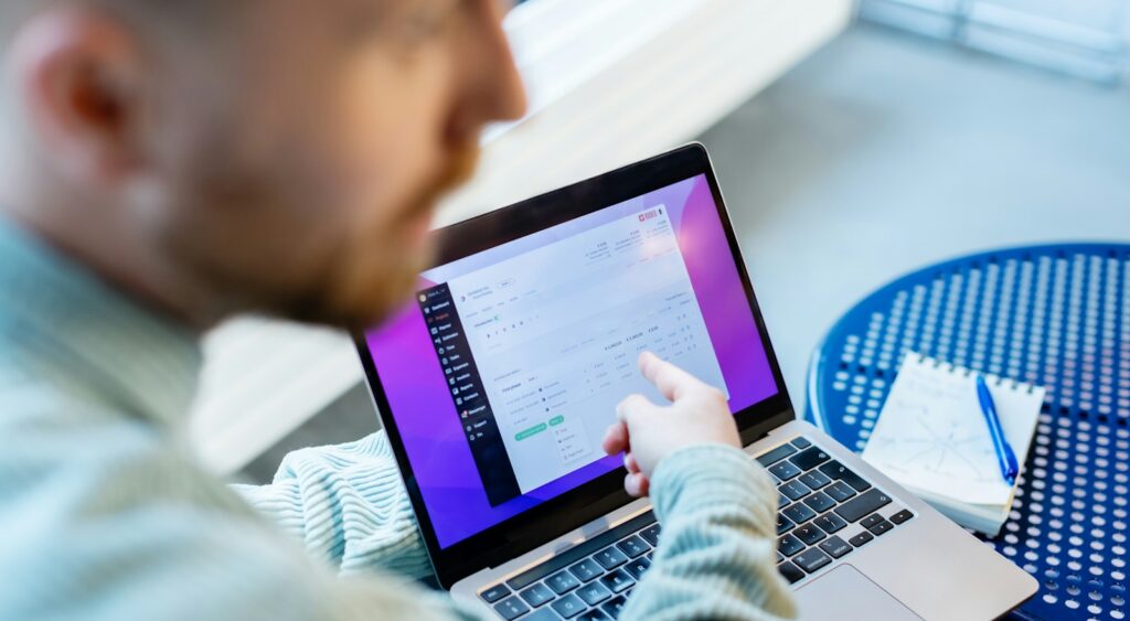 a man sitting at a table using a laptop computer